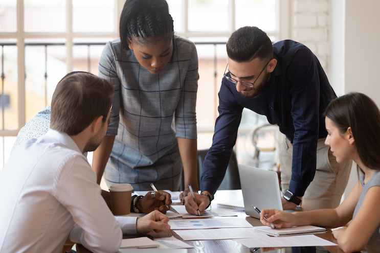 Focused leadership team people brainstorm on paperwork